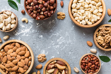mixed nuts in wooden bowl. Mix of various nuts on colored background. pistachios, cashews, walnuts,...