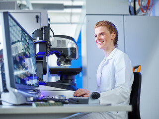 Happy scientist using desktop PC at E-Laboratory
