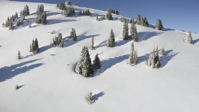 Aerial cinematic flyby over mountain pass peak with snowmobiler at top of Vail Pass Colorado Epic scenery day fresh snow