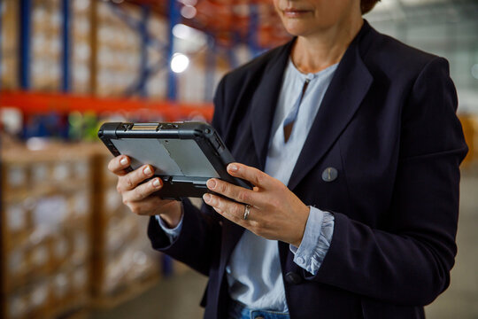 Manager with tablet PC standing in warehouse