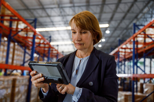 Mature manager using tablet PC at warehouse