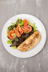 Baked turkey with vegetable fresh salad on plate