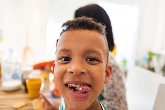 Happy boy eating breakfast at home