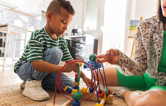 Mother assisting son in learning abacus at home