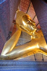 Gold Buddha image in sleeping or reclining lion pose or sihasaiyas, Wat Pho, Bangkok