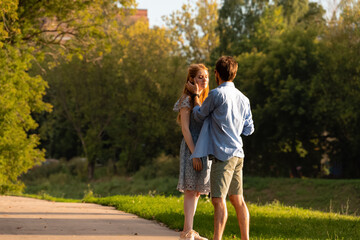 Young couple standing near each other and hugging. Man touching woman's face.