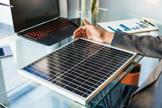 Businessman with solar panel at desk in home office
