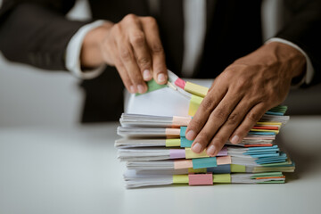 Businesswoman working in stacks of paperwork files for searching infomation unfinished documents about pile audit form on desk office and investigate financial doc in busy workload