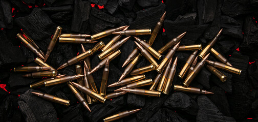 Cartridges for automatic carbine caliber .223 on charcoal. Ammunition for automatic and semi-automatic rifles. Dark back.