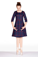 En Pointe heels together hands bra bas looking down full length Teachers perspective Young female dancer tartan dress pink satin pointe shoes Reference for teacher and student best feet position