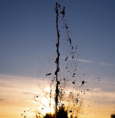 Wasserfontäne einer Quelle im Gegenlicht