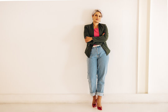 Confident Businesswoman Standing Against A Wall In An Office