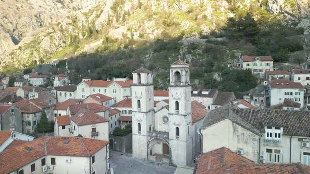 Drone panning shot over the roofs of houses in the city Kotor with a great view on the St Tryphon cathedral and the Adriatic sea.