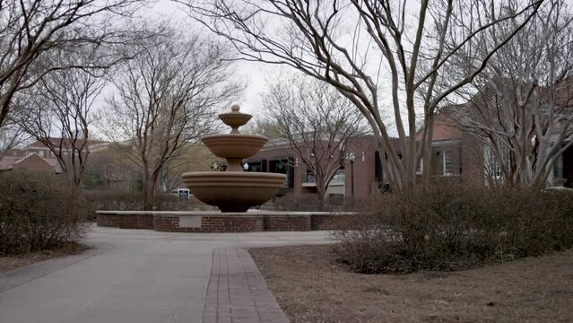Fountain with still water on the campus of Ole Miss in Oxford, Mississippi with video panning left to right.