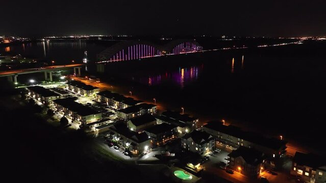 Hernado De Soto bridge in Memphis, Tennessee illuminated with Mighty Lights at night with drone video moving forward.