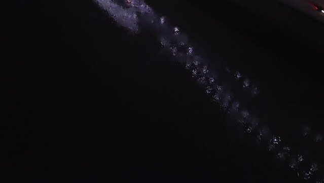 Hernado De Soto bridge in Memphis, Tennessee with illuminated Mighty Lights at night with drone video tilting up from Mississippi River.