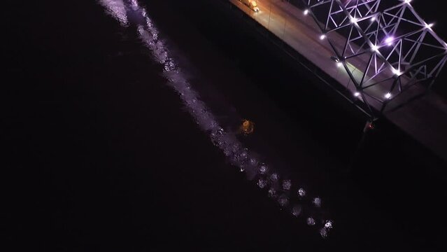 Hernado De Soto bridge in Memphis, Tennessee illuminated with Mighty Lights at night with drone video tilting up.