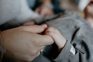 Fototapeta premium Closeup shot of the mother holding the hand of the newborn baby