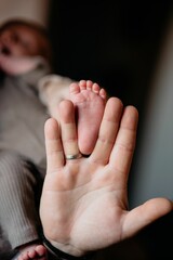 Closeup shot of the father holding the toe of the newborn baby