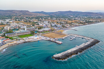 Marina Port Gouves - late afternno drone aerial photo, city landscape, buildings and blue water anb sandy beach