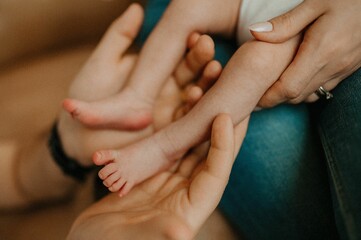 View of father playing with a newborn baby white mother holding him