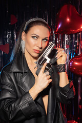 Fototapeta na wymiar Beautiful, brunette with a gun in her hands..in a leather coat.and black sexy lingerie
