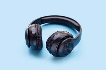 Black headphones on blue background.