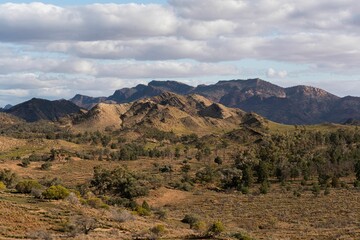 Landscape of mountains and trees under the cloudy sky.