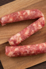 Raw Taiwanese sausage in garlic flavor in a plate on wooden table background.