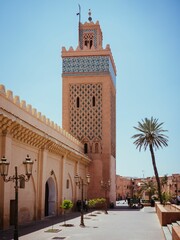 Fototapeta na wymiar Tower with palm trees under the blue sky in Morocco.