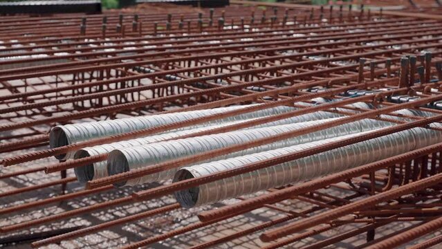 Metal reinforcing bars or rebar on a construction site waiting for the concrete to be poured. Orbiting right to left shot