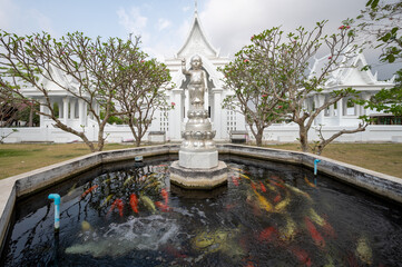 Chonburi, March 12, 2023. Wat Phon Prapa Nimit, This striking white Buddhist temple in a tranquil setting features a silver and mirrored interior. Fountain in the park