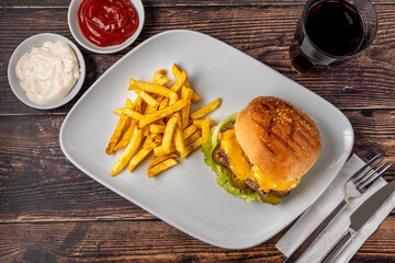 Delicious beef burger with french fries, onion rings and sauces