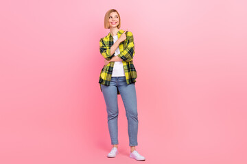 Naklejka premium Full size photo of pretty young girl finger point empty space dressed stylish checkered yellow outfit isolated on pink color background