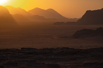 Wadi Rum w Jordanii. Słońce zachodzące za pustynne góry. 