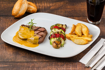 Grilled beef tenderloin with grilled vegetables on a white porcelain plate