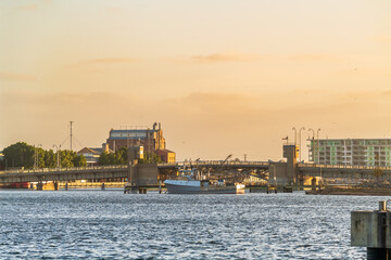 Industrial area of Port Adelaide with a fish boat and the Birkenhead Bridge across the Port River viewed at sunset time, South Australia