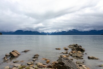 Beautiful landscape of blue mountains in front of the seashore with a cloudy sky in the background