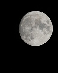 Vertical shot of the full Moon against a black background perfect for wallpapers