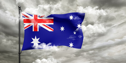 Australia national flag cloth fabric waving on beautiful sky grey Background.