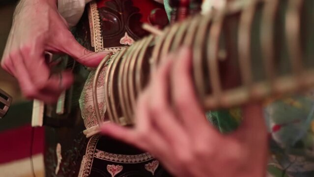 4K Close up of mans hands playing an Indian instrument called a sitar