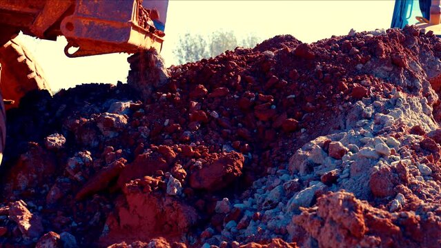 Large clay stones are dropped in a large pile. Stones are crumbling into small pieces. 50perc slow motion. 4K.