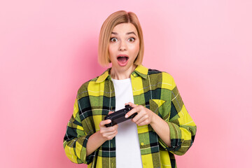 Photo of astonished positive girl hands hold controller play video games isolated on pink color background © deagreez