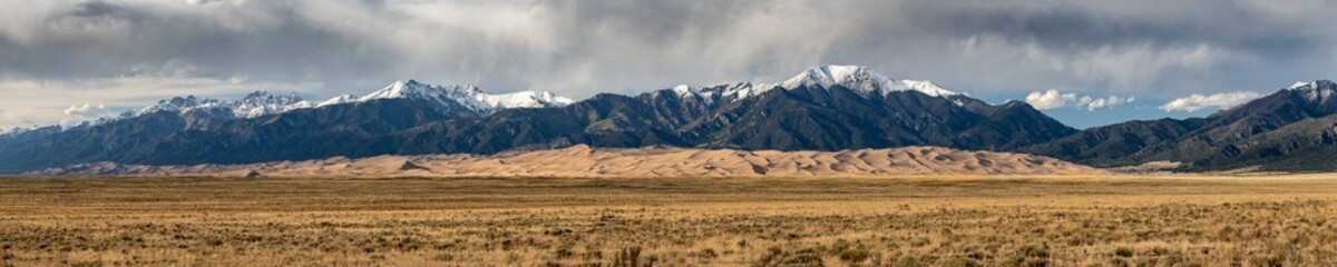 Panorama of Great Sand Dunes Below Snow Capped Mountains