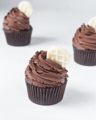 Chocolate cupcake with dark chocolate buttercream, double chocolate cupcakes with american buttercream, tall swirl frosting on a cupcake with a wafer