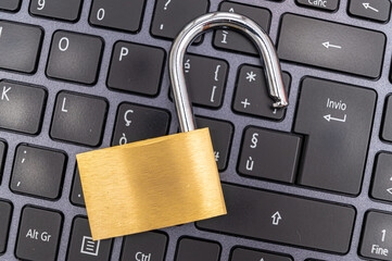 Open padlock, placed above a pc keyboard. Protection of personal and sensitive data, risk of intrusion. Privacy.
