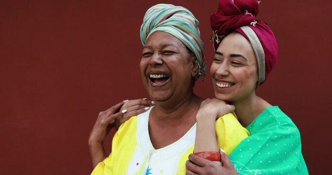 Happy african mother and her daughter having tender moment while wearing ethnic afro dress outdoor - Mom day, family and love concept 