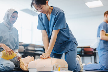 Medical students practicing CPR techniques on a manikin in simulation training
