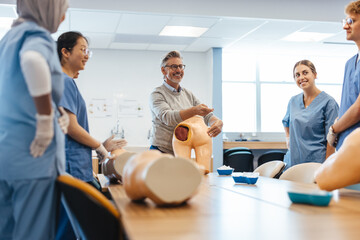Experienced medical practitioner giving injection training to young students in medical school