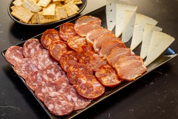 Different type of cut meat and cheese on a plate.